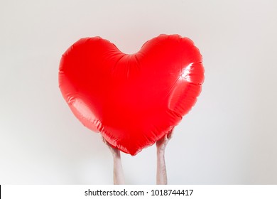 Hands Holding A Large Inflatable Heart Shape