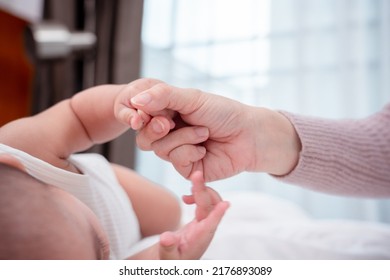 Hands Holding Of Mother Parent Soft Touch Newborn Baby Fingers Love Family Concept. Infant Child Portrait Happy Healthy.