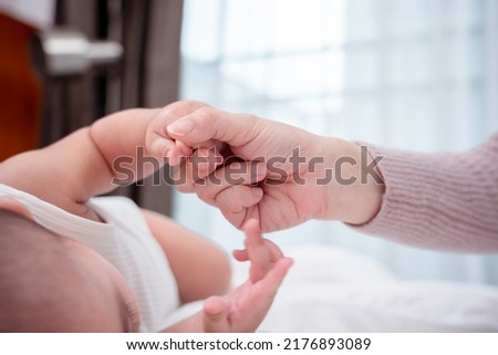 Hands holding of mother parent soft touch newborn baby fingers love family concept. Infant child portrait happy healthy.
