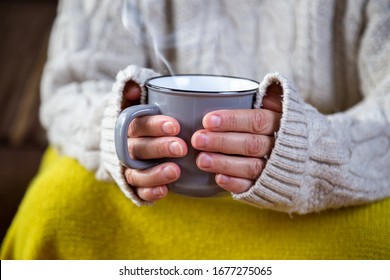 hands holding a mug with hot drink comfortably at home - Shutterstock ID 1677275065