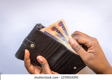 Hands Holding Nigerian Naira Notes And Leather Wallet Isolated On White Background. Black African Woman Counting Or Spend Money. For Personal Finance And Banking Concept