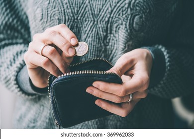 Hands Holding One Euro Coin And Small Money Pouch. Toned Picture