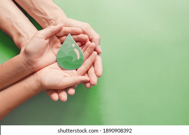 Hands Holding Paper Cut Green Oil Drop, CSR, Alternative Biofuel, Algae Fuel, Renewable Green Energy, Sustainable Living, ESG, Environmental Social Governance Concept 