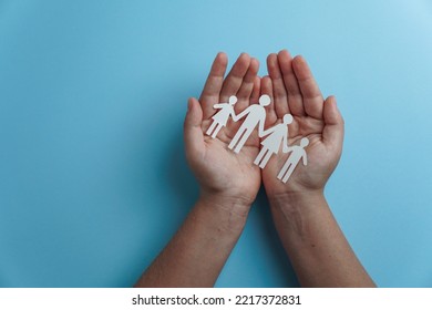 Hands Holding Paper Family Cutout, Life Health Insurance, Social Distancing Concept, Covid19,  On The Blue Color Background, Family Protection                               