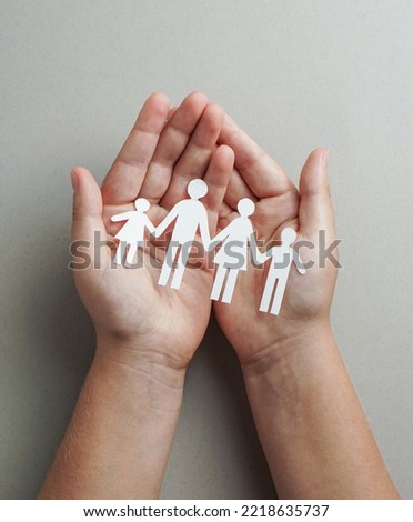 hands holding paper family cutout, life health insurance, social distancing concept, covid19,  on the grey color background, family protection                             