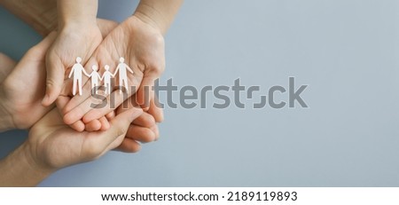Hands holding paper family cutout,adoption foster care, LGBT family mental health, life insurance. volunteer community concept