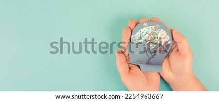 Hands holding paper head, human brain with flowers, self care and mental health concept, positive thinking, creative mind, generative AI used for brain