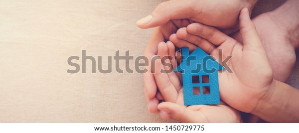 hands holding paper\
house, family home, homeless shelter and real estate, housing and\
mortgage crisis, foster home care, family day care, social\
distancing, lock down\
concept