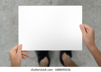 Hands Holding Paper For Map At Top View Walkway Background.