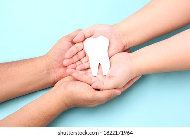 hands holding paper teeth on blue background. - Shutterstock ID 1822171964