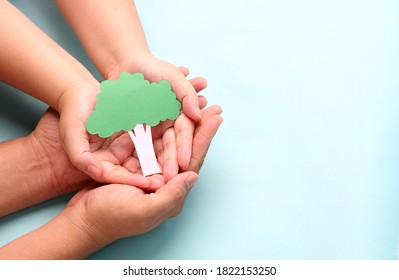 hands holding paper tree  on blue background. - Shutterstock ID 1822153250
