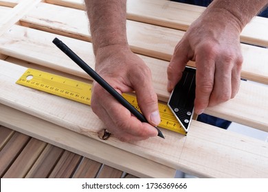 Hands holding pencil   construction ruler   drawing line  Senior man working at balcony during isolation  Closeup view  House improving  DIY   home decoration during quarantine concept