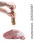 Hands  holding Pepper shaker and pork meat slice isolated on white background 
