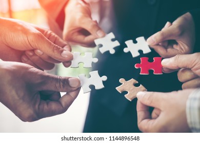 Hands holding piece of blank jigsaw puzzle for teamwork workplace success and strategy concept. - Shutterstock ID 1144896548