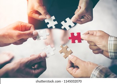 Hands holding piece of blank jigsaw puzzle for teamwork workplace success and strategy concept. - Shutterstock ID 1145032070