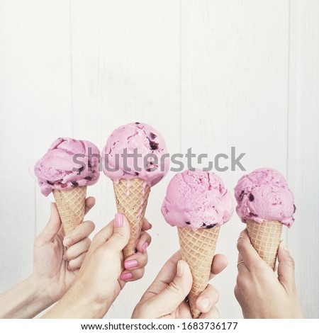 Hands holding pink ice cream cone with girls, Sanibel Island, Fl against white background by the ocean