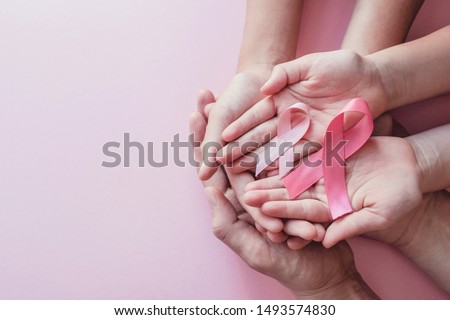 hands holding pink ribbons on pink background, Breast cancer awareness and October Pink day, world cancer day, national cancer survivor day