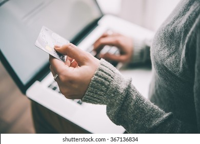 Hands holding plastic credit card and using laptop. Online shopping concept. Toned picture - Shutterstock ID 367136834