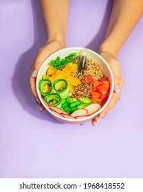 hands holding poke bowl on a purple background