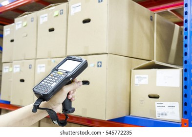 Hands Holding Portable Barcode Scanner In Warehouse 