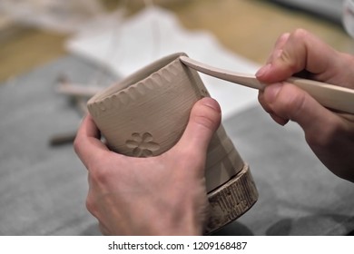 Hands holding pottery and processing tools close-up
