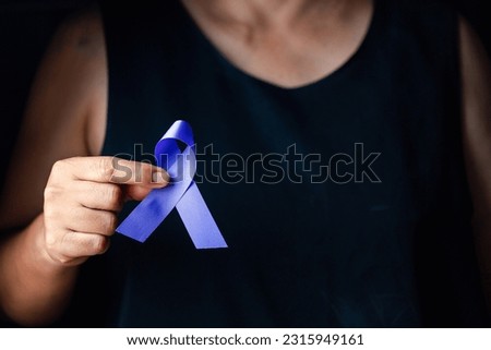 Hands holding purple ribbon symbol of Alzheimer disease, world Lupus. Day and world cancer day. Pancreatic cancer, fibromyalgia awareness, Epilepsy awareness, domestic violence awareness.