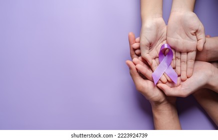 hands holding purple ribbons, Alzheimer's disease, Pancreatic cancer, Epilepsy awareness, world cancer day on a purple colored background, World Cancer Day concept - Powered by Shutterstock