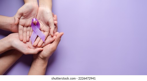 hands holding purple ribbons, Alzheimer's disease, Pancreatic cancer, Epilepsy awareness, world cancer day on a purple colored background, World Cancer Day concept - Powered by Shutterstock