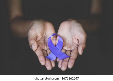 Hands holding Purple ribbons,  Pancreatic cancer, Epilepsy awareness, domestic violence awareness, Alzheimer disease, fibromyalgia awareness, world cancer day. - Shutterstock ID 1676162647