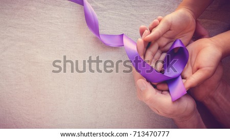Hands holding Purple ribbons, toning copy space background, Alzheimer disease, Pancreatic cancer, Epilepsy awareness, domestic violence awareness,fibromyalgia awareness, world cancer day