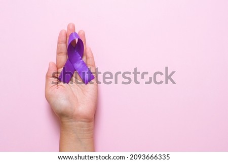 Hands holding Purple ribbons world cancer day concept, Alzheimer disease, Pancreatic cancer, Epilepsy awareness, domestic violence awareness, fibromyalgia awareness