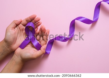 Hands holding Purple ribbons world cancer day concept, Alzheimer disease, Pancreatic cancer, Epilepsy awareness, domestic violence awareness, fibromyalgia awareness