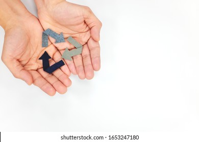 Hands holding a recycling symbol in white background. Flat lay with copy space. Recycled fabric and used clothes concept.