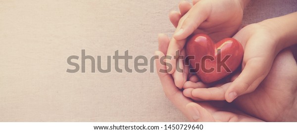 hands holding red heart, health care, hope, love,\
organ donation, mindfulness, wellbeing, family insurance and CSR\
concept, world heart day, world health day, world mental health\
day