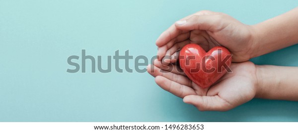hands holding red heart, health care, love, organ\
donation, mindfulness, wellbeing, family insurance and CSR concept,\
world heart day, world health day, world mental health day, praying\
concept