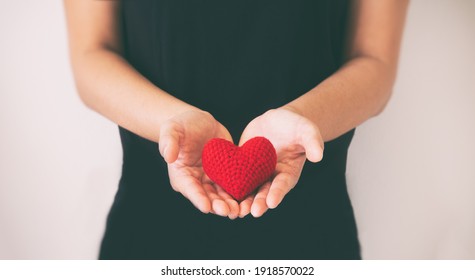 Hands holding red heart on black isolated background, copy space, concept of love, hope,healthcare,organ donation,insurance and CSR, World heart day, National Organ Donor day,World mental heath day.