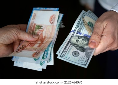 Hands holding russian rouble and us dollar bills. dollars and rubles. concept of currency exchange. - Shutterstock ID 2126764076