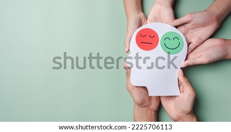 Hands holding sad face and happy smiley face on brain paper cut out, bipolar and depression, mental health concept, personality, mood change, therapy healing split concept