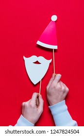 Hands Holding Santa Claus Christmas Photobooth Props On A Red Background