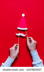 Hands Holding Santa Claus Christmas Photobooth Props On A Red Background