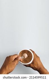 Hands Holding A Scoop Of Powder Vegan Protein Over White Background.