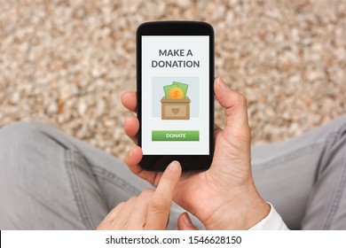 Hands holding smart phone with donation concept on screen. Top view