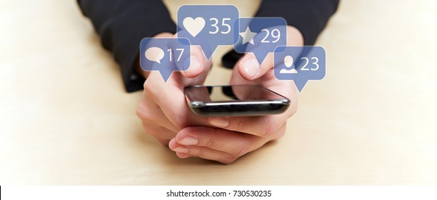 Hands holding smartphone with social media or social network notification icons