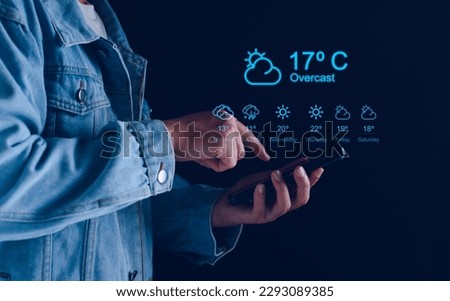 Hands holding smartphone with Weather forecast widget concept. cloudy, rainy and sunny day concept, touchscreen device with different seasons and daily temperature. Weather forecast for every day.