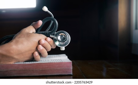Hands holding stethoscope   the Bible   pray for healing  concept for treatment  science   religion  close up hands praying  and copy space   space for text 