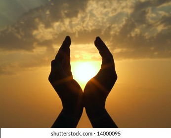 Hands Holding The Sun At Dawn