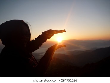 Hands Holding The Sun At Dawn