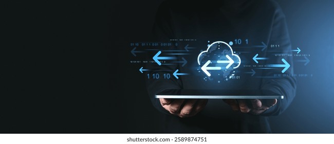 Hands holding a tablet with cloud storage and data transfer icons, glowing blue arrows, and binary code on a dark background, symbolizing remote network access - Powered by Shutterstock - Get 15% off with code: PIKWIZARD15