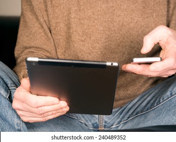Hands holding tablet and smartphone and tap text