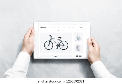 Hands holding tablet with sport webstore mock up on screen, isolated. Healthy lifestyle web page interface mockup. Internet website template. Web store screen layout for computer display.